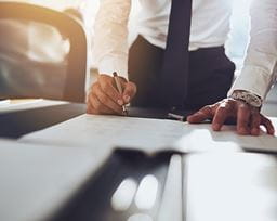Man signing documents on a desk