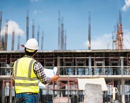 Construction worker looking at plans on site