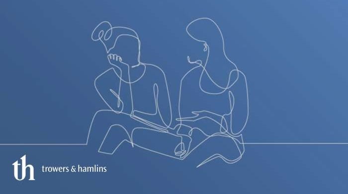 Line drawing of two women sitting and talking with blue background