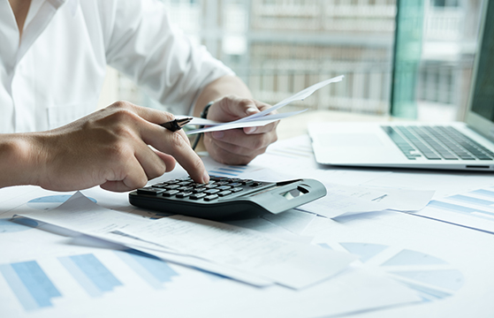 man using calculator at desk 